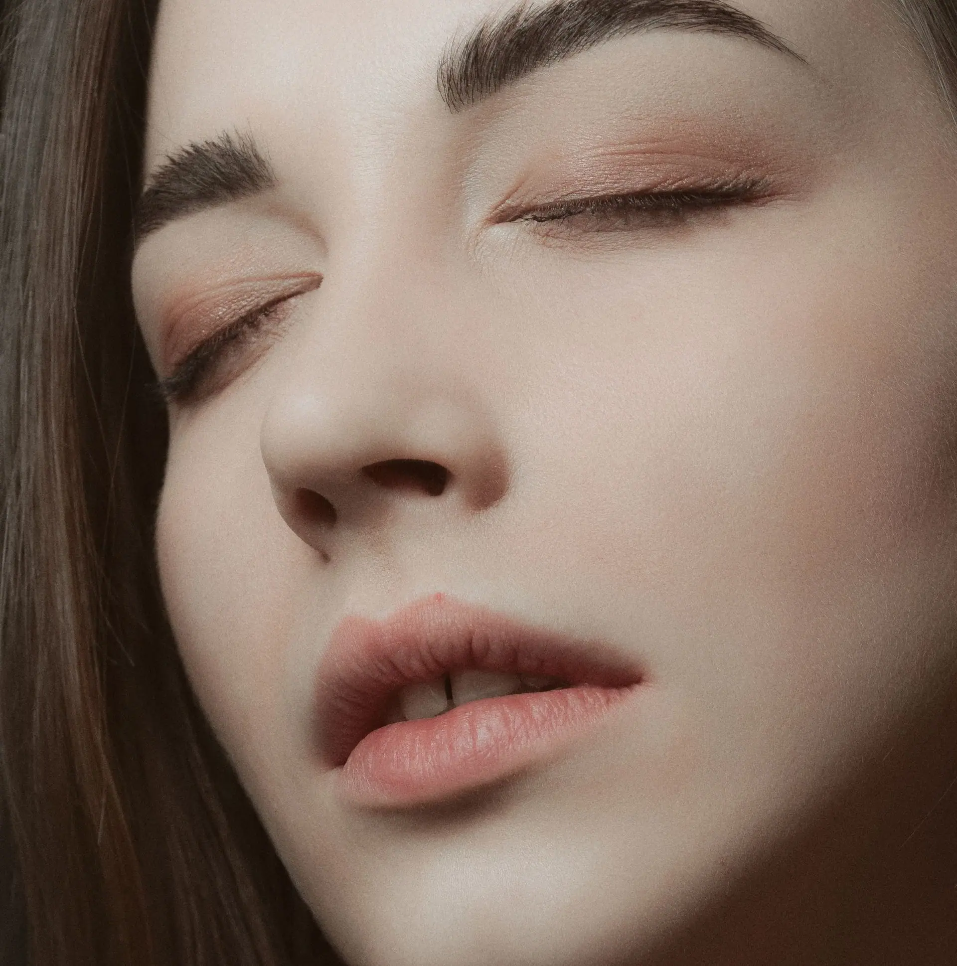 A woman with closed eyes and softly sculpted brows