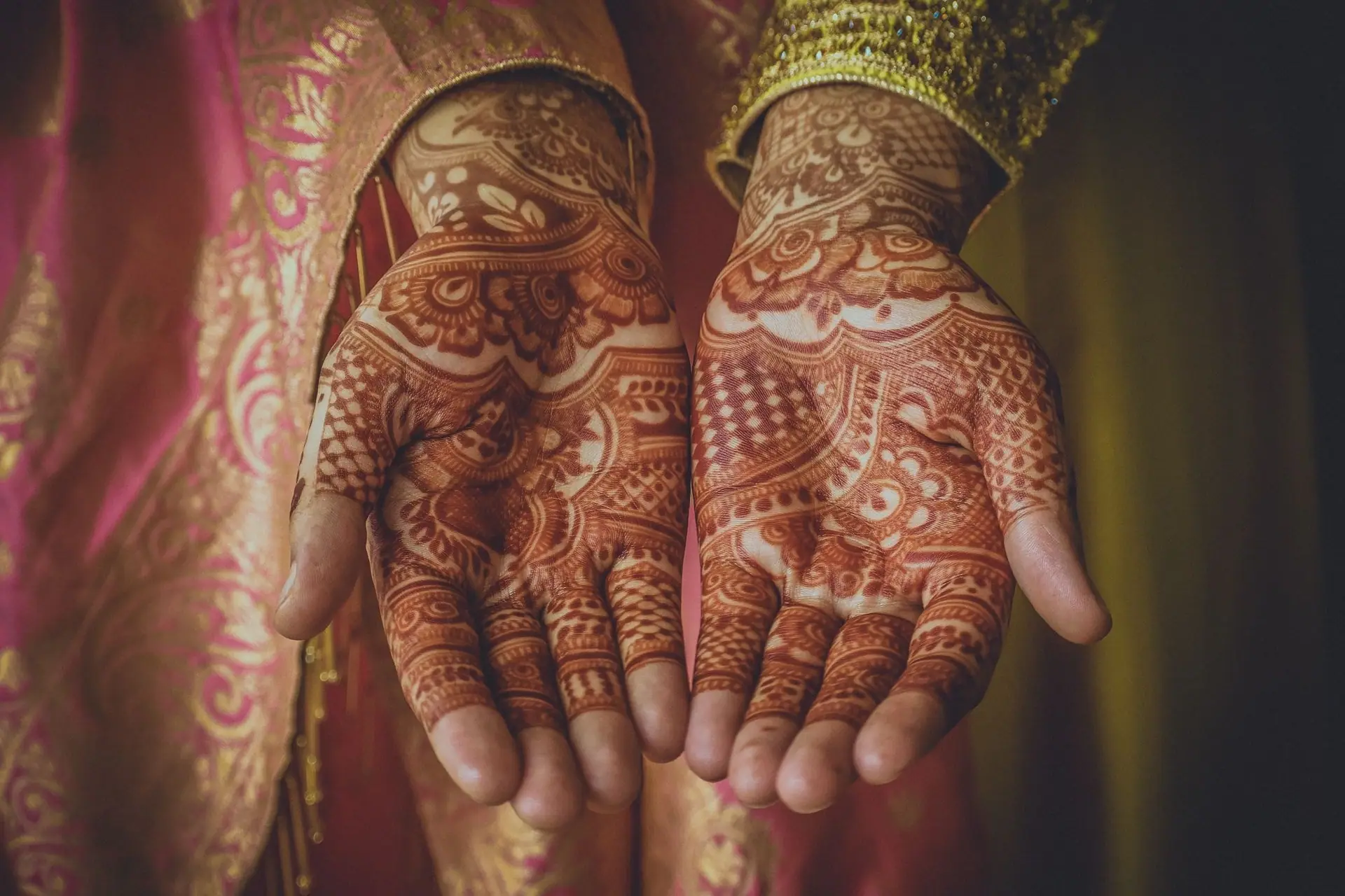 Open palms covered in fine bridal henna